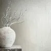 Kırık beyaz ve gümüş tonlarında hafif ışıltılı dokulu düz desenli podyum esintili lüks duvar kağıdı